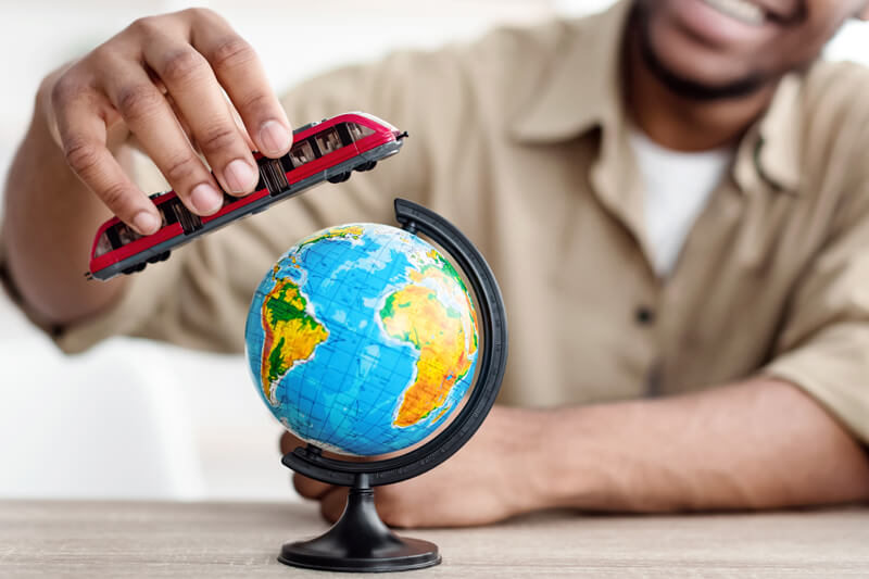 black-man-playing-with-train-model-and-globe-at-ho